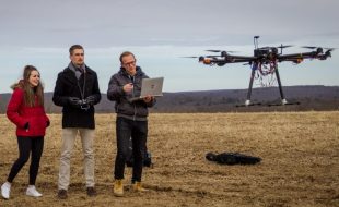 From left, Kerry Jones '19 (ENG), Ryan Heilemann '19 (ENG), and Josh Steil '19 (ENG) look on as their drone takes off for a test flight on Horsebarn Hill in Storrs. (Christopher Larosa/UConn Photo)